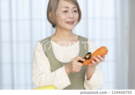 老婦人在廚房削蔬菜 老婦人在廚房削蔬菜 134400793
