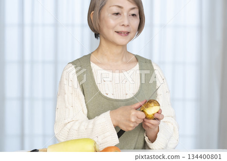 Senior woman peeling vegetables in the kitchen Senior woman peeling vegetables in the kitchen 134400801