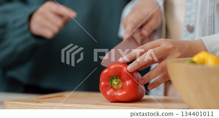 Cooking Party: Close-Up of Friends Chopping Red Pepper Together 134401011
