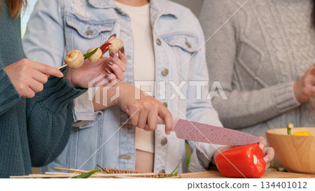 Party preparation with friends cooking and enjoying food together 134401012