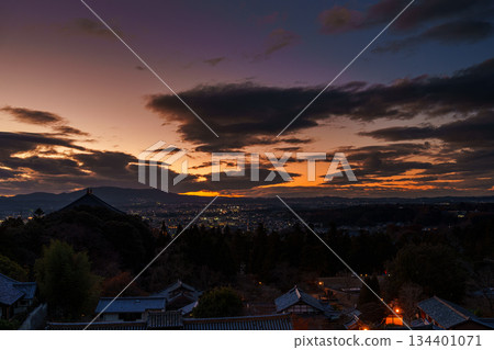Nara in December: Sunset sky from Todaiji Temple's Nigatsudo Hall. The city of Nara is getting brighter and the sky is lit up by the beautiful sunset. 134401071