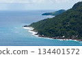 Granite coastline stretches into the distance with waves washing over rocks. Seychelles, Mahe. 134401572
