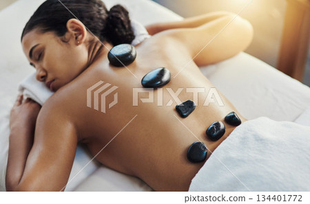 Woman, sleeping and stone massage at spa for skincare, beauty or body treatment on bed at resort. Calm female lying in relaxation with hot rocks on back for physical therapy, zen or wellness at salon 134401772