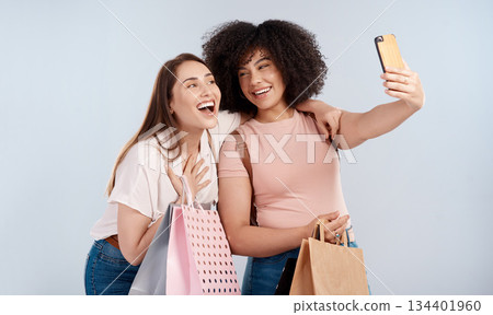 Friends, women with shopping bag and happy in selfie, retail customer and fashion isolated on studio background. Excited female people smile in picture, sale and discount with promotion at boutique 134401960