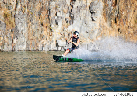 Splash, wakeboarding and water board with man in lake for extreme sports, summer break and travel vacation. Wave, adrenaline junkie and fitness with guy on river for health, adventure and training Splash, wakeboarding and water board with man in lake for extreme sports, summer break and travel vacation. Wave, adrenaline junkie and fitness with guy on river for health, adventure and training 134401995