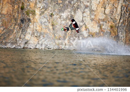 Jump, wakeboard and extreme sports with man in lake for action, summer break and travel vacation. Wave, adrenaline junkie and fitness with guy surfing on river for health, adventure and speed Jump, wakeboard and extreme sports with man in lake for action, summer break and travel vacation. Wave, adrenaline junkie and fitness with guy surfing on river for health, adventure and speed 134401996