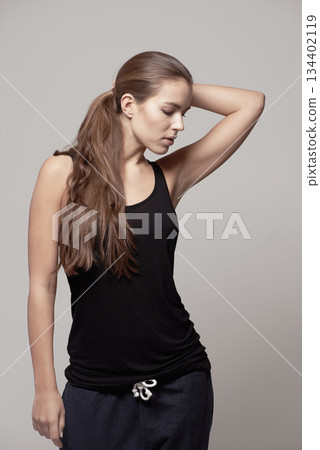 Fashion, casual and woman in a studio with fitness apparel, outfit or clothes and confidence, isolated on grey studio background. Pose, natural beauty and female model with cool style or athleisure 134402119