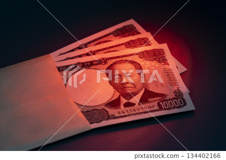 A stack of 10,000 yen bills peeking out of an envelope symbolizes large amounts of money and financial imagery 134402166