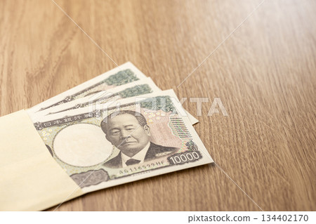 Japanese 10,000 yen bills unfolding from an envelope and the concept of funds 134402170