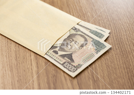 Image of Japanese yen funds with 10,000 yen bills peeking out of an envelope 134402171