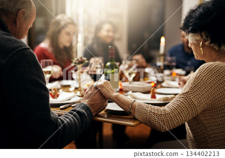 Food, thanksgiving and hand holding with family at table in dining room for holiday, prayer or worship. Celebration, support and gratitude with people praying at home for kindness, dinner and love 134402213