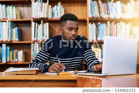 Laptop, library and university student with research, learning and planning for exam, report or focus on studying, goals and education. Black man, college and working on task, essay or scholarship 134402231