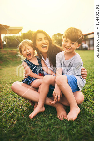 Mother, happy kids or hug playing on grass for fun bonding in summer outside a house in nature. Funny mom hugging playful children on garden playground outdoors with happiness of family together Mother, happy kids or hug playing on grass for fun bonding in summer outside a house in nature. Funny mom hugging playful children on garden playground outdoors with happiness of family together 134402391