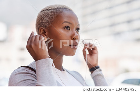 Music, thinking and vision with a business black woman in the city on her morning commute into work. Mindset, future and earphones with a young female employee streaming audio in an urban town 134402453