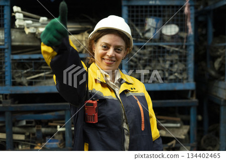 Portrait of technician women worker stand, looking camera happy smiling in garage scrap yard car workshop warehouse. Portrait of technician women worker stand, looking camera happy smiling in garage scrap yard car workshop warehouse. 134402465