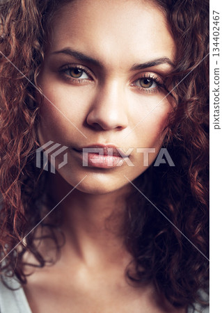 Beauty, closeup and portrait of woman in studio confident, beautiful and gorgeous on gray background. Salon, facial glow and face of female person with natural makeup, cosmetics and curly hairstyle 134402467