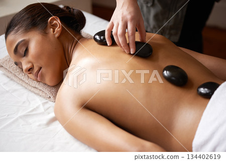 Girl, hands or back massage with rocks in spa to relax for zen, sleeping or wellness physical therapy. Woman, rest or calm client in salon to exfoliate for body healing treatment or hot stone therapy 134402619