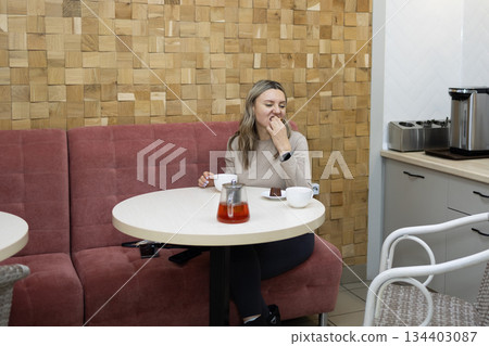 Woman Enjoys Dessert and Tea at a Cafe With Modern Wood Wall 134403087