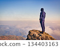 Back view of a person standing on the summit and looking towards the future | Challenge and goal concept 134403163