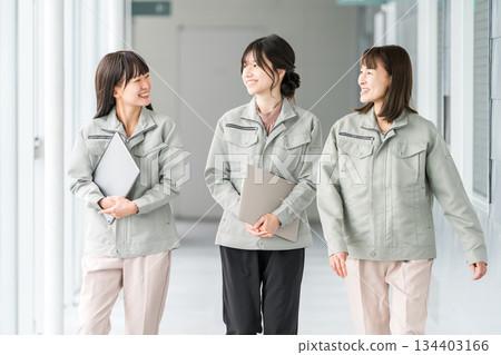 Female staff in the manufacturing, building, transportation, and construction industries wearing work clothes. 134403166