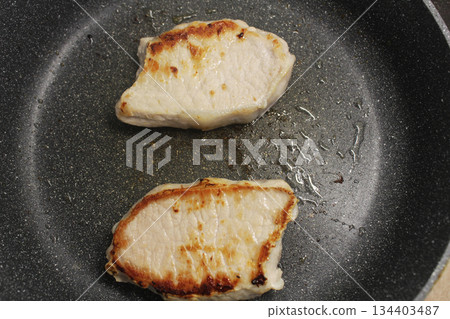 Two fried pieces of meat in a pan. Cooking the steak. Two fried pieces of meat in a pan. Cooking the steak. 134403487