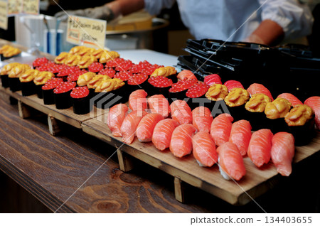 Many pieces of sushi made from salmon and unagi on the wooden tray for selling Many pieces of sushi made from salmon and unagi on the wooden tray for selling 134403655