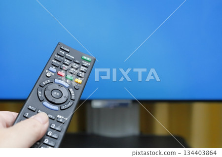 Person operating TV remote control 2 134403864