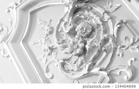 Ornate baroque-style floral wall decoration accentuated with pristine white surface Ornate baroque-style floral wall decoration accentuated with pristine white surface 134404699