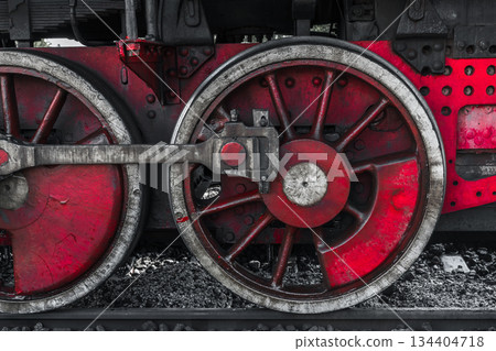 A detailed view of a red steam locomotive wheel set, showing weathered metal A detailed view of a red steam locomotive wheel set, showing weathered metal 134404718
