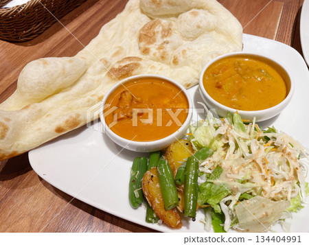 Naan, butter chicken curry, and vegetable curry: An authentic Indian curry set. Naan, butter chicken curry, and vegetable curry: An authentic Indian curry set. 134404991