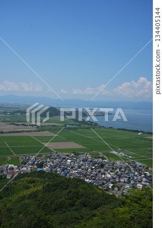 A bird's-eye view of the rice paddy fields on the lake shore and the blue sky from Mt. Yawata in summer, copy space 134405144