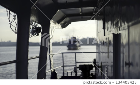 Tugboat sailing away on a wide river at sunset. Clip 134405423