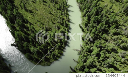Turquoise river flowing through green forest and rocky mountains. Media 134405444