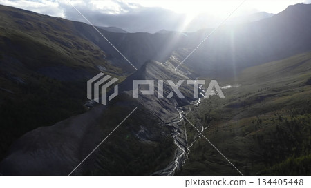 Sunlight illuminating mountain valley with river. Media 134405448