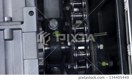 Industrial chain drive rotating inside machinery. Media 134405449