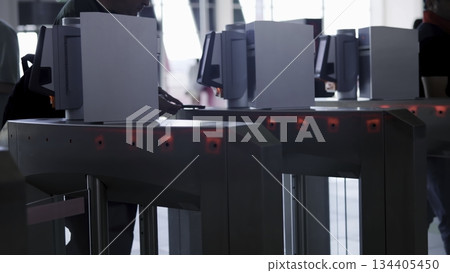 Passengers passing through automatic turnstile gates. Media Passengers passing through automatic turnstile gates. Media 134405450