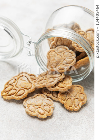 Homemade paw print dog treats spilling from jar Homemade paw print dog treats spilling from jar 134405464