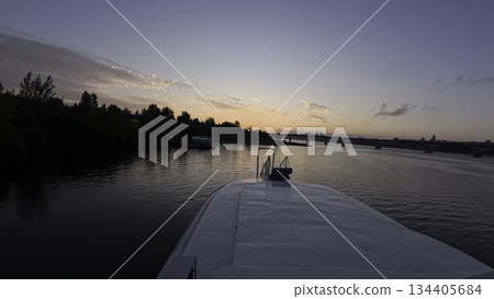Ship cruising on a river at sunset towards a bridge. Clip Ship cruising on a river at sunset towards a bridge. Clip 134405684