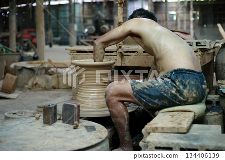 Selective focus on the clay work on the spinning tray with hands of worker Selective focus on the clay work on the spinning tray with hands of worker 134406139