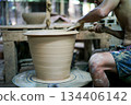 Selective focus on the clay work on the spinning tray with hands of worker 134406142