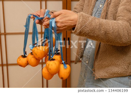 A woman holding persimmons before they are dried A woman holding persimmons before they are dried 134406199