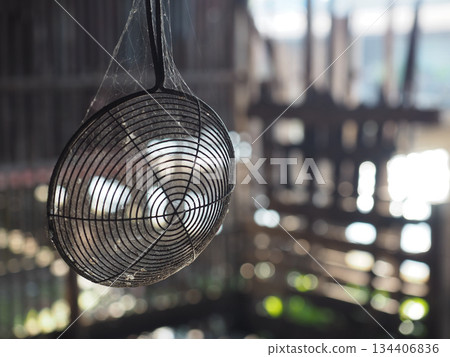 Old wire strainer spiderweb dust rustic kitchen metal utensil soft sunlight bokeh background vintage mood hanging Old wire strainer spiderweb dust rustic kitchen metal utensil soft sunlight bokeh background vintage mood hanging 134406836