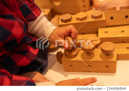 Baby's hands playing with natural wooden building blocks Baby's hands playing with natural wooden building blocks 134406844