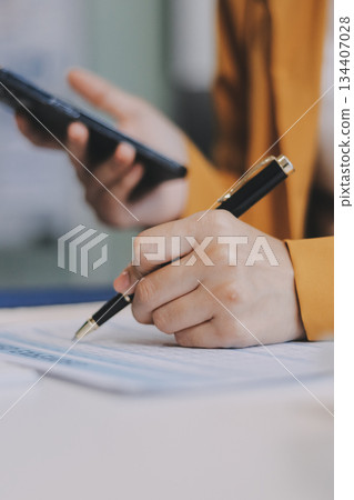 Business woman using calculator for do math finance on wooden desk in office and business working background, tax, accounting, statistics and analytic research concept. 134407028