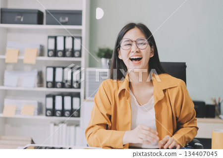 Business woman using calculator for do math finance on wooden desk in office and business working background, tax, accounting, statistics and analytic research concept. 134407045