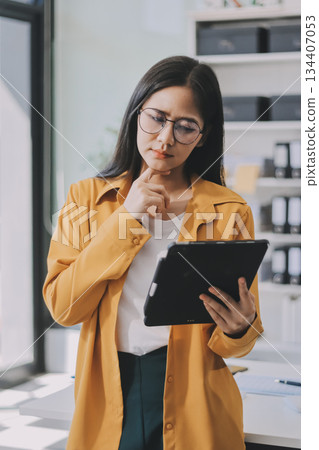 Business woman using calculator for do math finance on wooden desk in office and business working background, tax, accounting, statistics and analytic research concept. Business woman using calculator for do math finance on wooden desk in office and business working background, tax, accounting, statistics and analytic research concept. 134407053