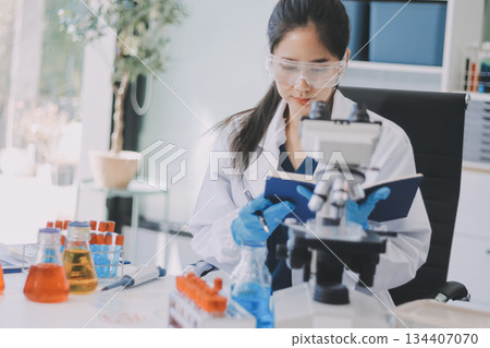 Portrait, science and happy woman on laptop in lab to research chemistry, test or innovation. Microscope, scientist and face of medical doctor in goggles for microbiology, healthcare or pharma study 134407070