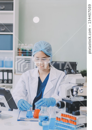 Portrait, science and happy woman on laptop in lab to research chemistry, test or innovation. Microscope, scientist and face of medical doctor in goggles for microbiology, healthcare or pharma study 134407089