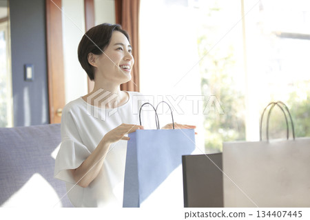 A woman looking happy as she opens her shopping bag 134407445