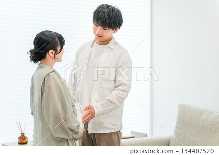 A couple in the living room of their home, a pregnant woman (maternity) A couple in the living room of their home, a pregnant woman (maternity) 134407520